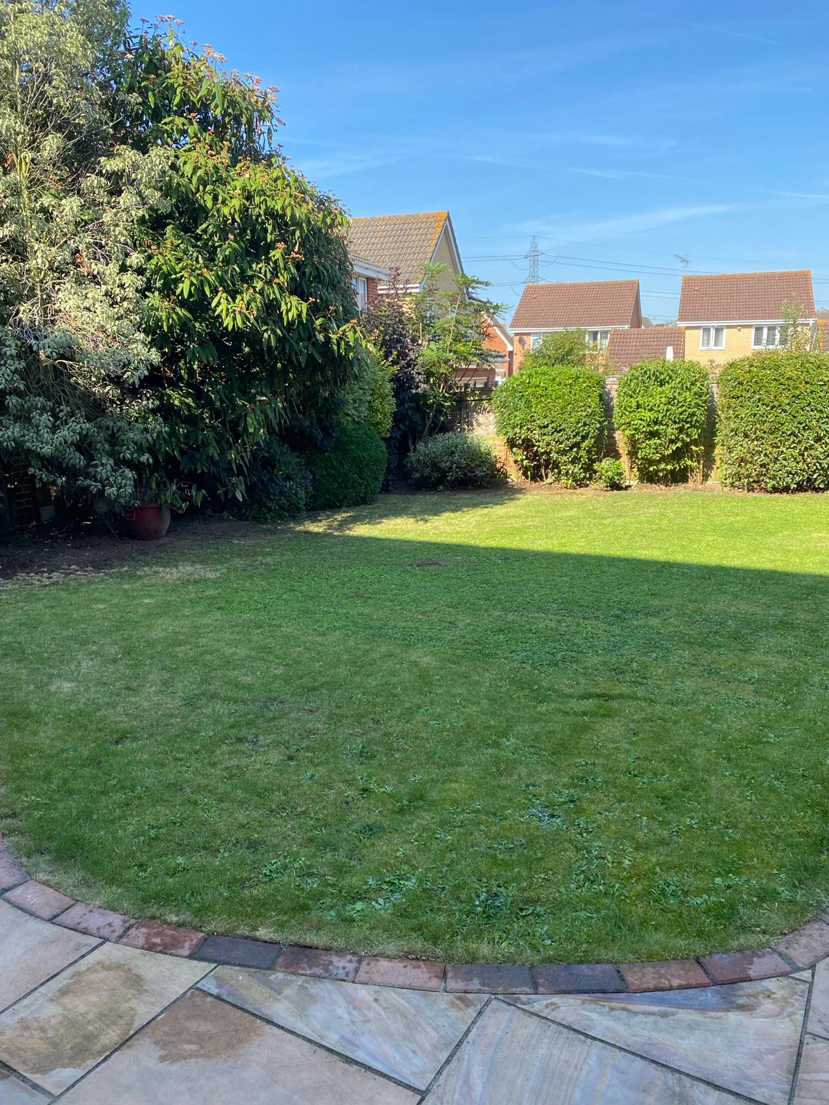 Neatly cut lawn and cleaned patio edging in a Grays back garden