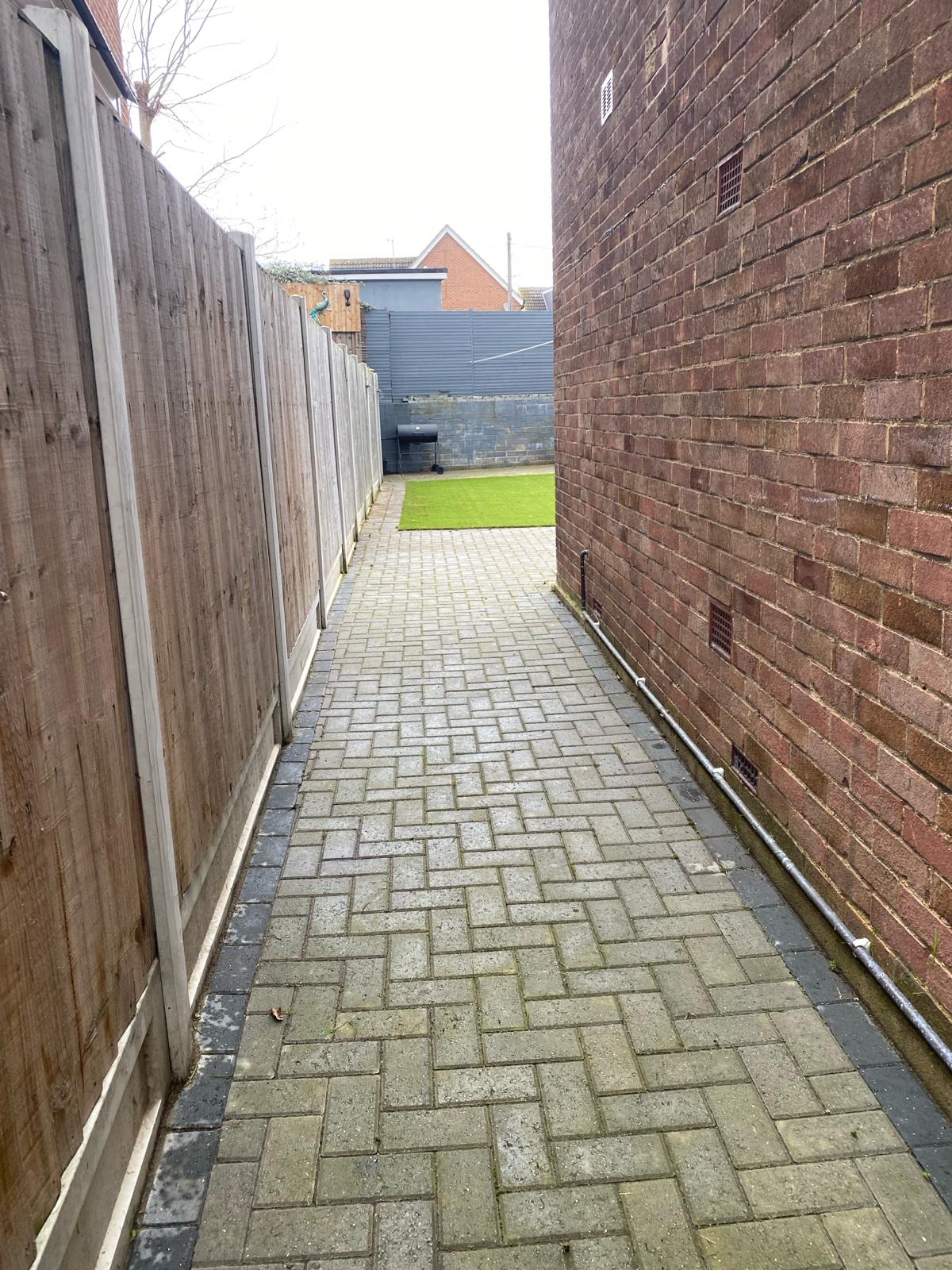 Cleaned block paved side passage leading to a tidy rear garden